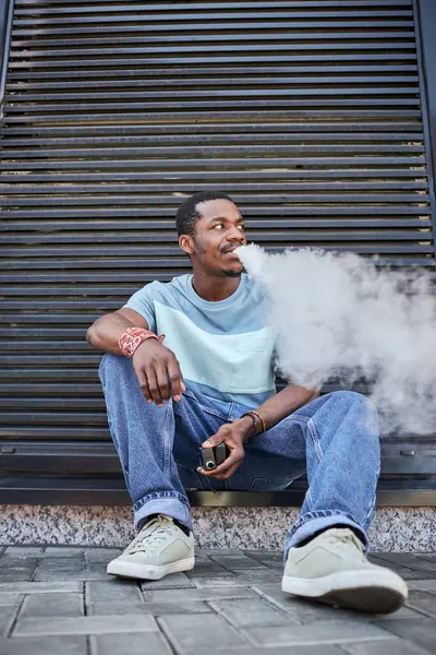 Jovem Afro Americano Descansado Casualwear Sentado Calçada Pela Parede Edifício — Fotografia de Stock