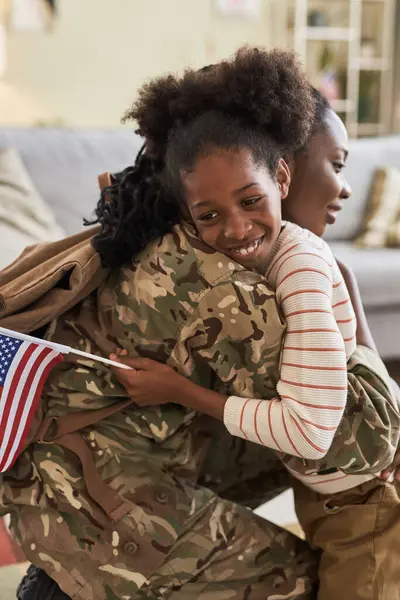 Vertical image of happy daughter meeting her mom from war, they embracing each other at home