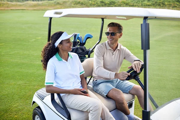 Porträtt Multietniskt Sportigt Par Som Kör Golfvagn Utomhus Och Ler — Stockfoto