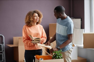 Çok ırklı bir ailenin taşınma sırasında eşyalarını konteynırlara koyması.