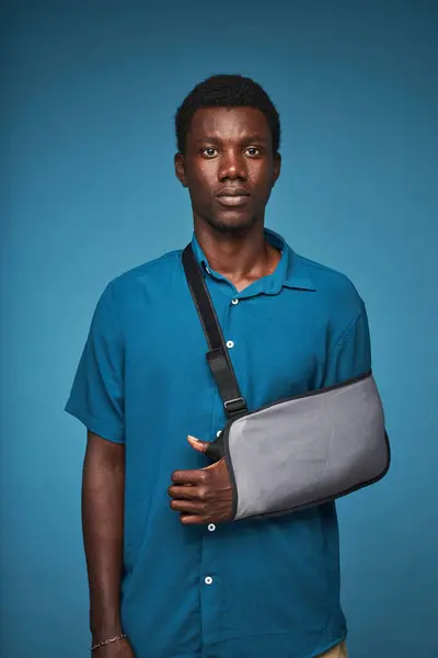 Vertical Portrait Young Black Man Wearing Arm Sling Vibrant Blue — Stock Photo, Image
