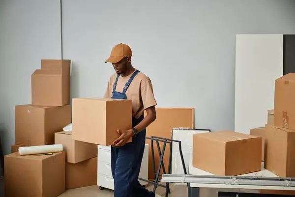 Lavoratore Afroamericano Uniforme Che Trasporta Scatole Cartone Durante Trasferimento Nuovo — Foto Stock
