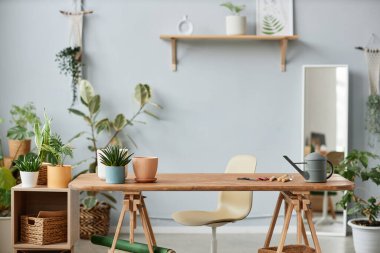 Bahçıvanların iş yerlerinin, canlı bitkilerin ve ahşap masanın olduğu minimum arkaplan görüntüsü, kopyalama alanı