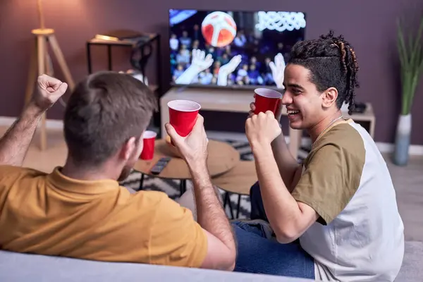 一群兴奋的体育迷在家里看电视篮球赛和喝啤酒 — 图库照片