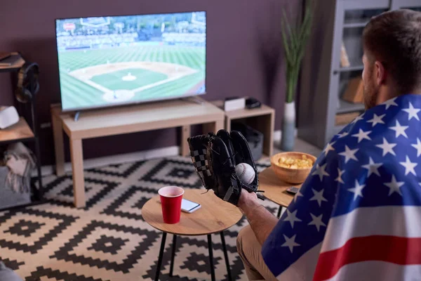 体育爱好者在家里看电视看棒球比赛的侧视图 身穿美国国旗 复制空间 — 图库照片