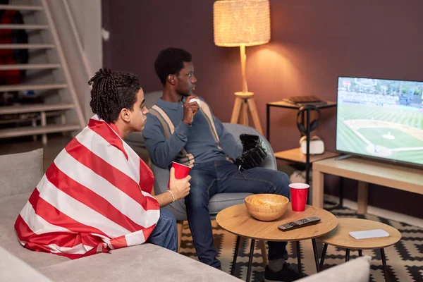 两个朋友在客厅看电视体育比赛和喝啤酒的肖像 — 图库照片