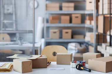 Yöneticinin işyerinin bir kısmı, birçok rafı olan geniş depolama odasında online müşteriler tarafından sipariş edilen ürün ve giysileri paketliyor.