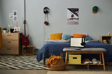 Birkaç yastıklı ve kulaklıklı ve boş ekranlı boş kulaklıklı rahat çift kişilik yataklı ev odasının bir kısmı.