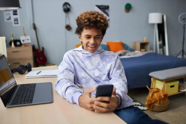 Smiling Teenager Casualwear Sitting Desk Using Mobile Phone While Communicating — Stock Photo, Image