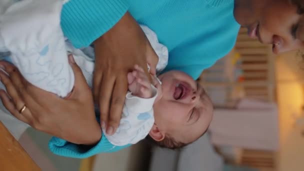 泣いている赤ん坊を落ち着かせる若いBiracialの女性の垂直ウエスト 彼の腕に注意深く保持 — ストック動画