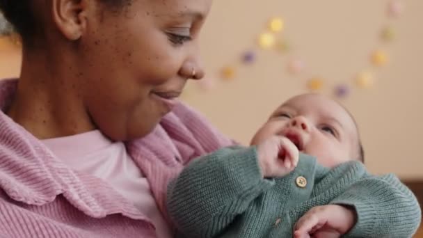 若い美しいアフリカ系アメリカ人女性のメディアクローズアップを保持し 自宅で泣いている乳児の息子をロック — ストック動画
