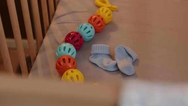 Geen Mensen Neergeschoten Van Kleine Lichtblauwe Babysokken Kleurrijk Rammelspeelgoed Matras — Stockvideo