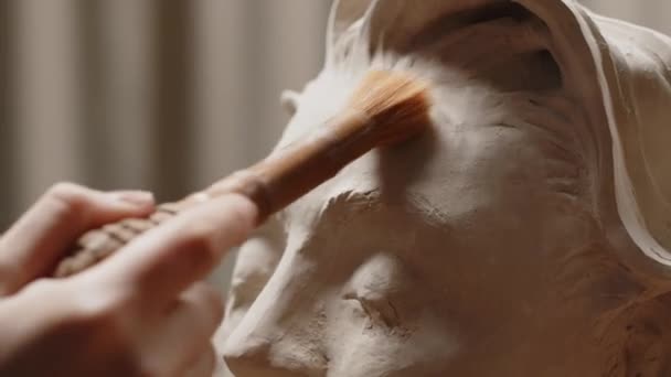 Zbliżenie Nierozpoznawalny Rzeźbiarz Sprzątanie Gliny Popiersie Młodej Kobiety Pędzlem Podczas — Wideo stockowe