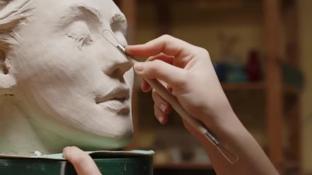 车间制作粘土女人脸肖像时 采用特殊造型工具对无法辨认的女雕塑家进行遮挡 — 图库视频影像