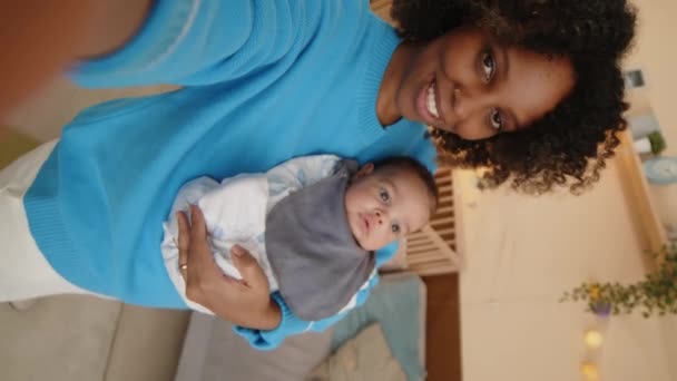 年轻的母亲带着婴儿儿子在家里度过白天的视频 手持垂直拍下她的照片 — 图库视频影像