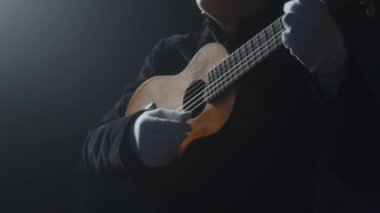 Dramatik bayan pandomimci, göz yaşı makyajlı, siyah arka planda sahne performansı sırasında eldivenli eldiven çalan sahne sanatçısı.