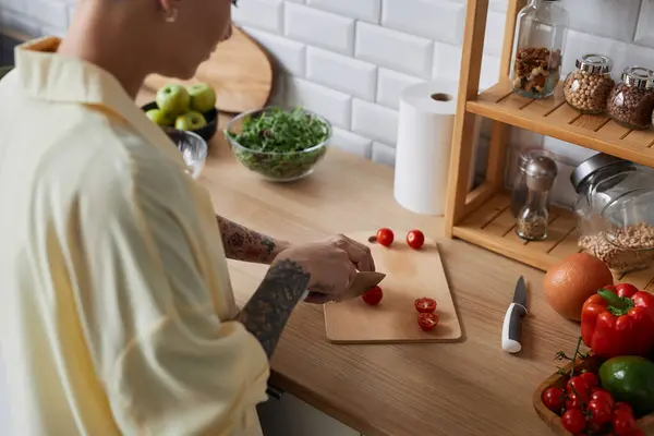 キッチンで健康的な食事と野菜を切断する入れ墨された女性の高角度のクローズアップ — ストック写真
