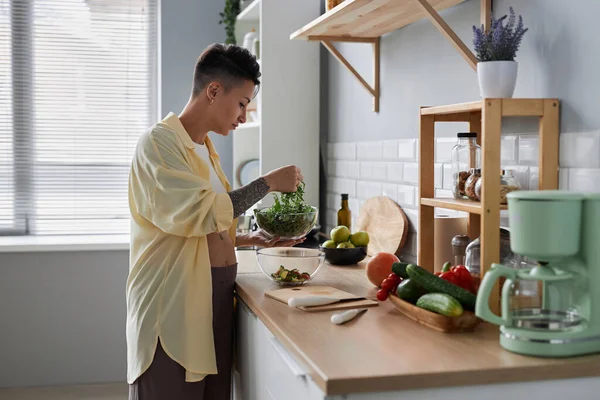 キッチンで健康的な食事を作り 緑のハーブでサラダを作る妊娠中の若い女性のサイドビューの肖像画 — ストック写真