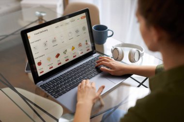 Bakkal teslimatı için online alışveriş sitesi kullanan genç kadına yüksek açı görünümü, kopyalama alanı