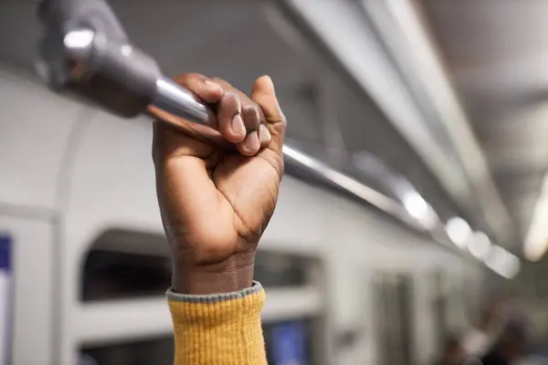 在地铁里紧紧抓住扶手的非裔美国人的特写镜头 — 图库照片