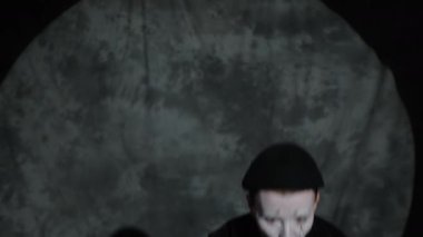 Sahne ışıkları altında sahne performansı sırasında kadın pandomimcinin renkli sihirli kıyafetlerle hokkabazlık yapması.