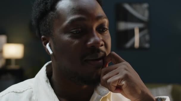 Genç Siyahi Adamın Kablosuz Kulaklıklarla Yerindeki Arkadaşlarıyla Görüntülü Konuşma Görüntüsü — Stok video