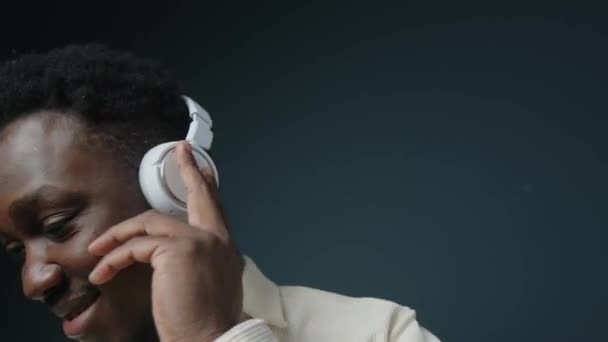 Średnie Zbliżenie Młodego Nieostrożnego Czarnego Człowieka Słuchającego Muzyki Bezprzewodowych Białych — Wideo stockowe
