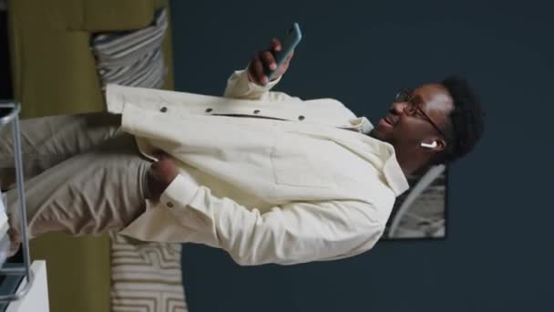 Genç Siyahi Bir Adamın Akıllı Telefon Aracılığıyla Kablosuz Kulaklıklardan Konuştuğu — Stok video