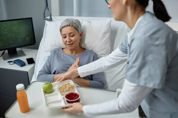 Young Nurse Bringing Tray Food Sick Mature Woman Who Lying — Stock Photo, Image