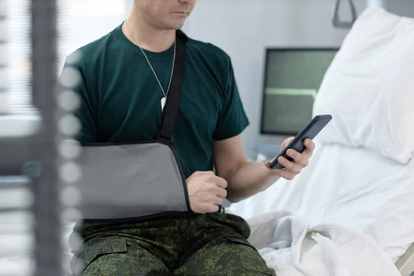 Ung Soldat Bandage Armen Läser Meddelande Sin Mobiltelefon Medan Han — Stockfoto