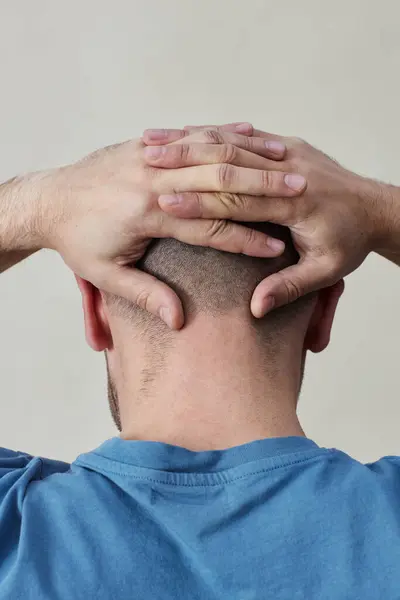 Minimal back view at man with bald head against white background