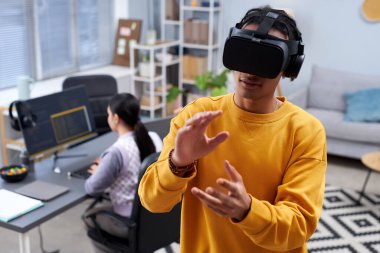 Bilgi işleme ofisinde VR kullanan siyahi bir gencin belden yukarı portresi ve el kol hareketi, kopyalama alanı