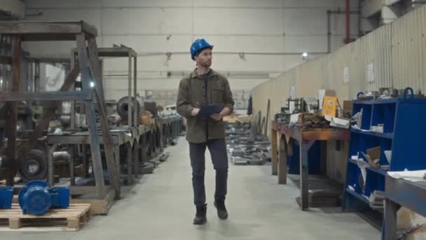 공장에서 Cnc 기계를 검사하는 보드에 체크리스트를보고 파란색 모자에 코카서스 운영자의 — 비디오