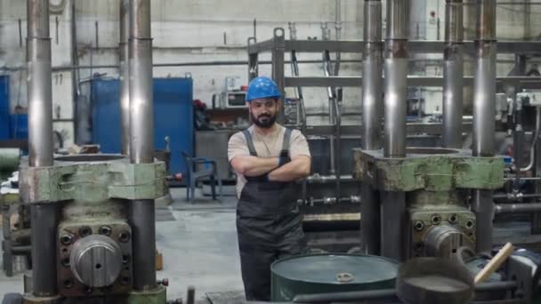 穿着工作服和硬帽站在两台液压压力机中间手挽手的中东男性工厂工人的跟踪画像 — 图库视频影像