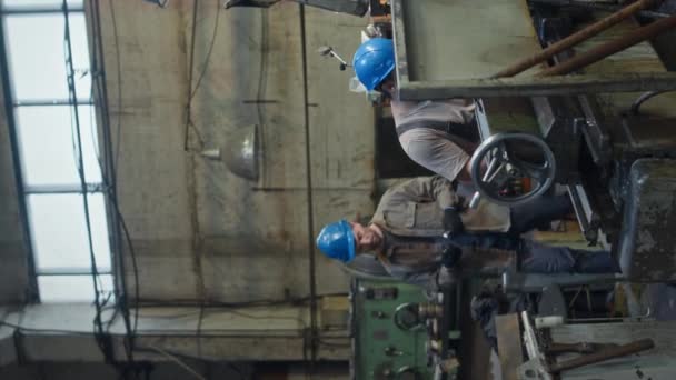 Вертикальная Средняя Съемка Двух Различных Мужских Промышленных Механиков Работающих Токарном — стоковое видео