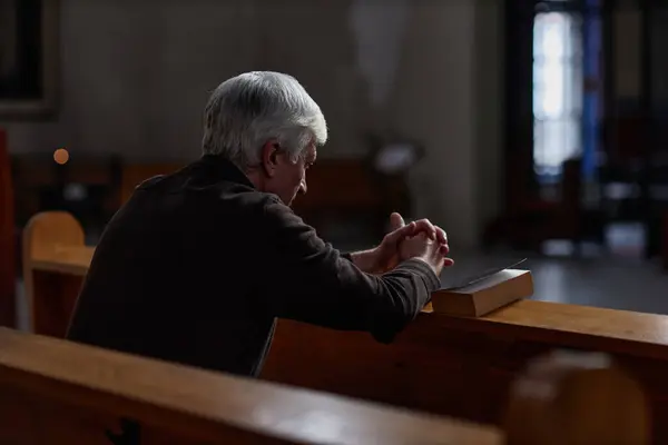 Visão Traseira Homem Sênior Sentado Banco Com Bíblia Orando Igreja — Fotografia de Stock