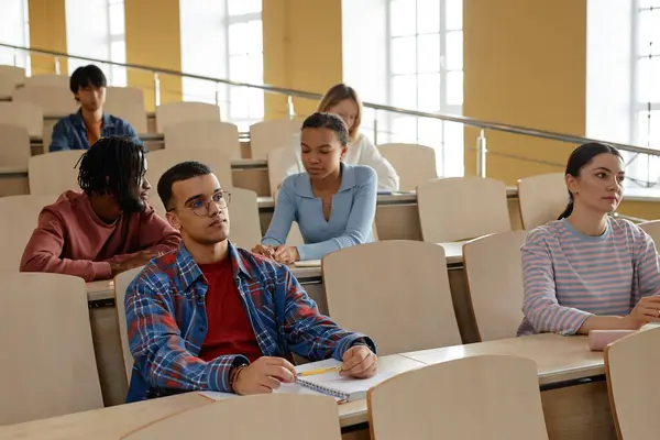 Bir Grup Üniversite Öğrencisi Ders Masasında Oturup Konferans Salonunda Öğretmenlerini — Stok fotoğraf