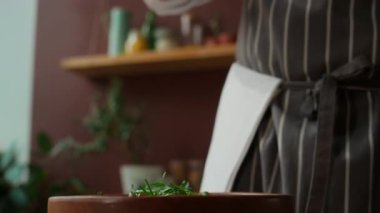 Tanınmayan bir aşçının yeşil salataya tohum serptiği bir kare.