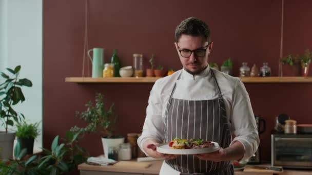 유니폼과 안경을 코카서스 요리사의 초상화 스테이크와 접시에 카메라에 — 비디오