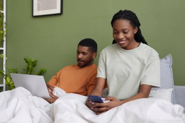 Afrika kökenli Amerikalı genç çift hafta sonları evlerinde dinlenirken alet kullanıyorlar.