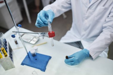 Laboratuvarda deney yaparken, bilim adamının sıvıyı test tüpüne koyup uzayı kopyaladığı yakın plan.