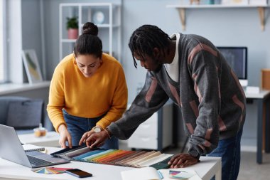 Ofisteki takım çalışması sırasında iç mekan için renk seçen iki tasarımcı