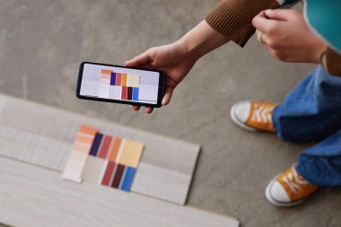 Tasarımcının akıllı telefonunun zemininin farklı renklerini gösteren yüksek açılı görüntüsü