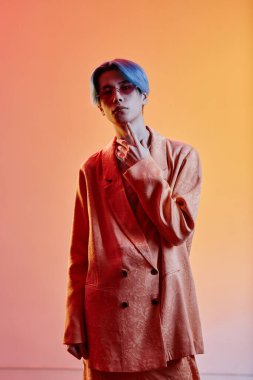 Renkli arka planda kameraya bakan Asyalı bir adamın dikey görüntüsü