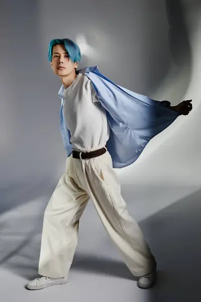 Mavi Saçlı Şık Giyinmiş Gri Arka Planda Egzersiz Yapan Genç — Stok fotoğraf