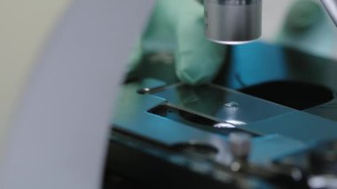 Tanımlanamayan bir bilim adamının cam kaydırağına damlatarak laboratuvarda araştırma yaparken mikroskop altında incelemesi.