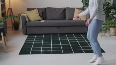 Beyaz, yaşlı, sağlıklı bir kadının iç spor eğitimi sırasında ip atlama görüntüsü.