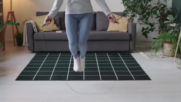朝の自宅で心臓トレーニングをしている間にロープでジャンプする陽気な白人高齢女性のショットをキルティング — ストック動画