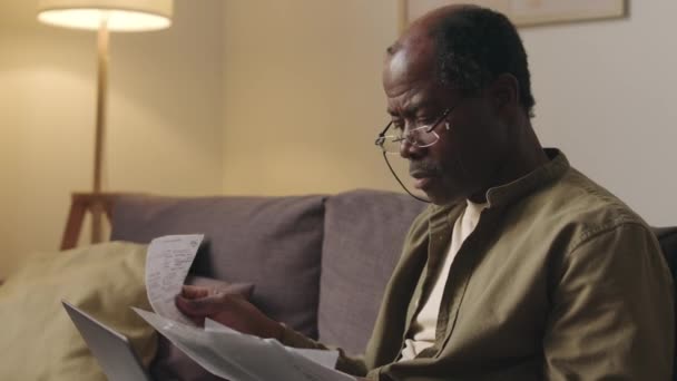 Tilting Medium Shot Senior Black Man Glasses Studying Bills Receipts — Stock Video