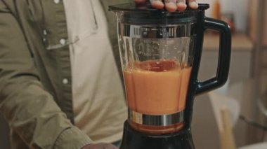 Olgun Afrikalı Amerikalı adamın evde blender 'da detoks smoothie yaparken çekilmiş bir fotoğrafı.